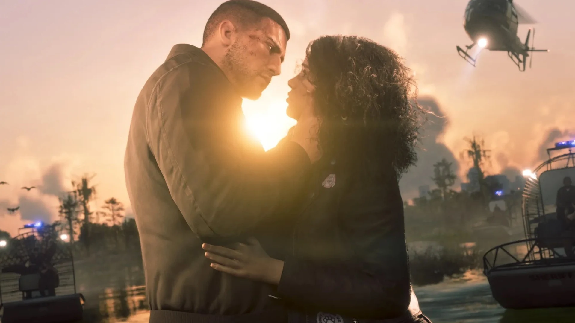 Jason et Lucia s'enlacent au coucher du soleil sous le passage d'un hélicoptère